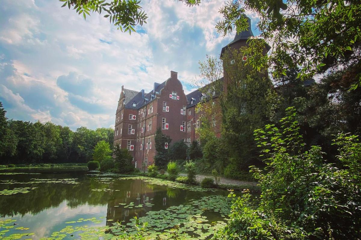 Schloss Bedburg mit Wassergraben, Standort des Miderma Studios für Lippenpigmentierung bei Köln